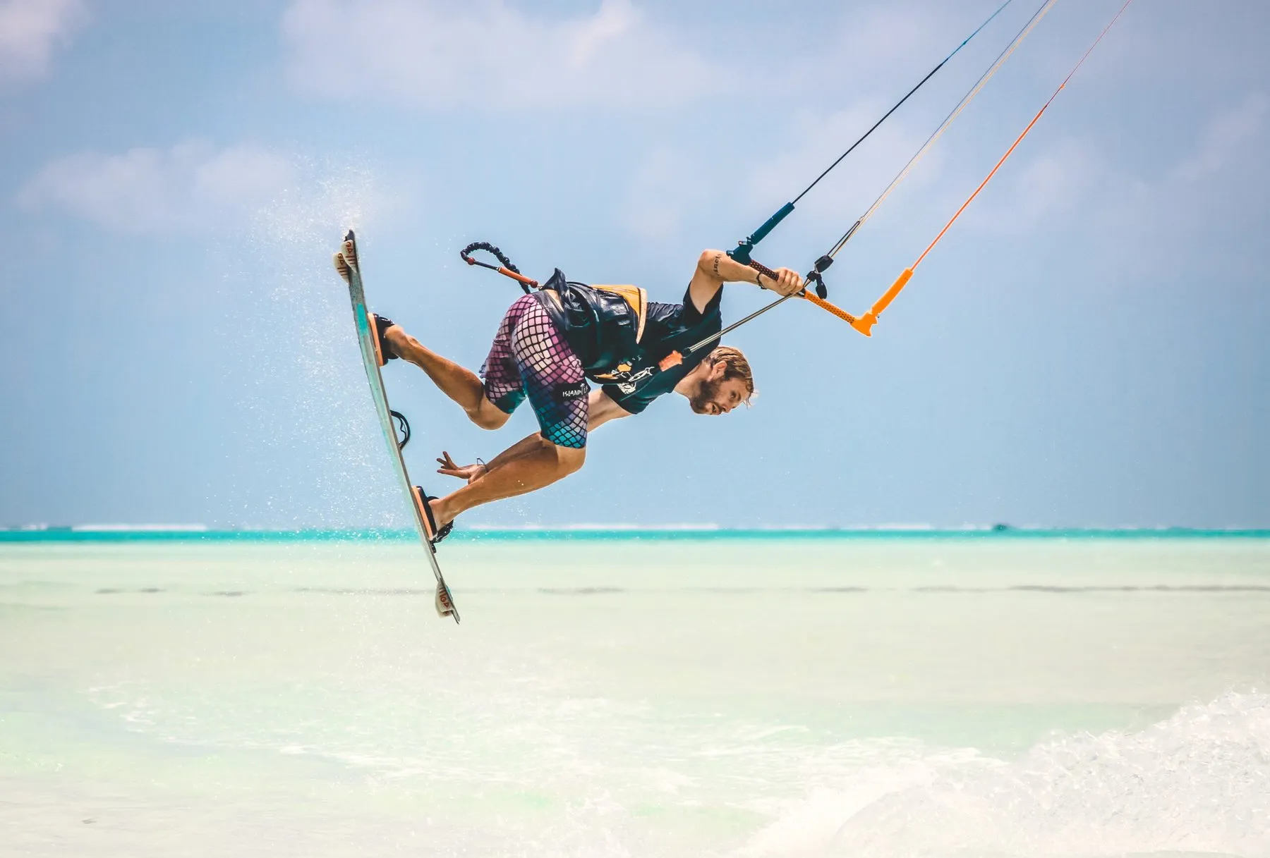 Kitesurfer springt in der Luft über türkisem Meer